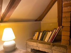 a lamp and a stack of books on a fireplace at City Centre Cascade Sweet Home in Yerevan
