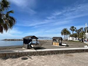Una playa con un pabellón y un barco en la playa. en Luxury Home on the beach, en Málaga