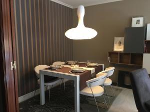 a dining room with a table and white chairs at Playa de Boiro in Boiro