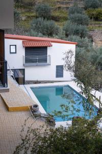 a swimming pool in front of a house at Casa das Pias in Ribalonga