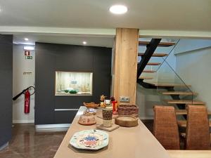a dining room with a table and a staircase at Casa das Pias in Ribalonga