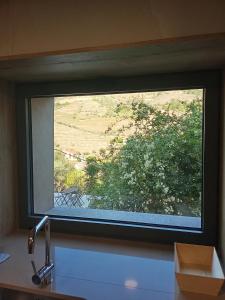 a window in a kitchen with a view of a field at Casa das Pias in Ribalonga