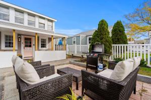 a patio with two wicker chairs and a grill at The Addie Shack Pet Friendly Steps to Beach in Salisbury