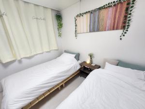 two beds sitting next to each other in a room at SweetJian SweetStay in Suwon
