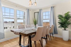 a dining room with a table and chairs and windows at Sunset Views Balcony Marsh Views AC in Hampton