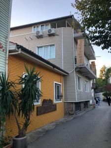 un edificio giallo con una palma di fronte di Kaleiçi müstakil benzersiz bahçeli HARİKA EV a Antalya (Adalia)