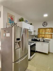 une cuisine avec un réfrigérateur en acier inoxydable dans l'établissement Casa acogedora en Bavaro, Ciudad del Sol, à Punta Cana 16 autres photos