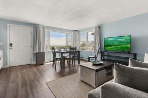 Una sala de estar con una mesa y un televisor. en Atlantic Dream Ocean Views Minutes to Beach, en Rye 30 fotos más