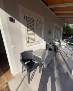 a patio with chairs and a table and a window at Villa Gersi in Divjakë