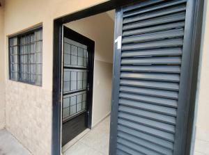 eine Tür, die zu einem Raum mit zwei Fenstern führt in der Unterkunft Apto Completo - Ar Condicionado e Garagem 01 in Barretos + 1 Foto