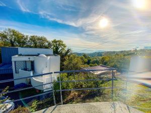 a balcony of a house with the sun in the sky at Appartement sur les hauteurs de Clermont-Fd in Orcines