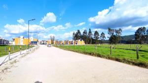 a dirt road in a field with buildings in the background at Casa Familiar para Descanso en Paipa in Paipa