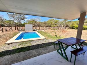 a patio with a table and a swimming pool at Cabañas Corozalito Naturaleza aves y tranquilidad cerca de playas Corozalito Punta Islita San Miguel Coyote Bejuco Costa de Oro entre otras in Corozalito
