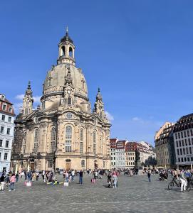 a large building with people standing in front of it at Cozy Voyage - Frauenkirche 1 - Zentral und ruhig in Dresden +7 photos