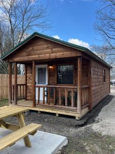 a log cabin with a picnic table in front of it at Sister Lakes Glamping Cabin at Wonder Woods #3 in Dowagiac