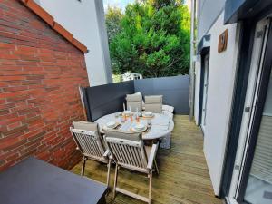 a patio with a table and chairs on a balcony at Lachmoewe-by-DeJu in Norderney