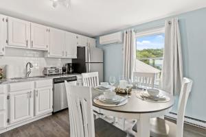 a kitchen with a table and chairs and a kitchen with white cabinets at The Sunrise Deck Ocean Views Private Deck in Rye