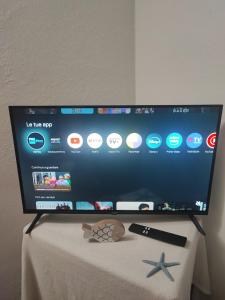 a flat screen tv sitting on top of a table at Emadi House Porto Rotondo in Porto Rotondo