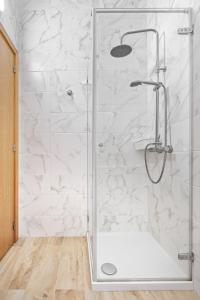 e bagno con doccia e pareti in marmo bianco. di Sunny House with Patio, Walk to Attractions a Vila Nova de Gaia