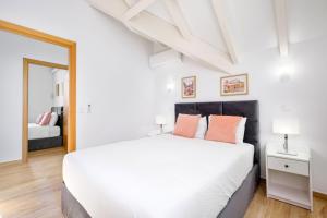 una camera da letto con un grande letto bianco e uno specchio di Sunny House with Patio, Walk to Attractions a Vila Nova de Gaia