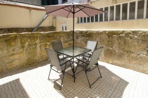un tavolo con due sedie e un ombrellone di Sunny House with Patio, Walk to Attractions a Vila Nova de Gaia