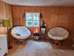 two chairs in a room with wooden walls at Cosy Cabin close to Lake in Ludvigsborg