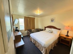 a hotel room with a bed and a desk at Lakeside Motel in Moses Lake
