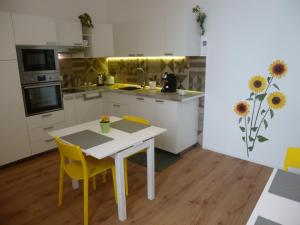 a kitchen with a white table and yellow chairs at Il Faro Trapani b&b Rooms & apartments in Trapani