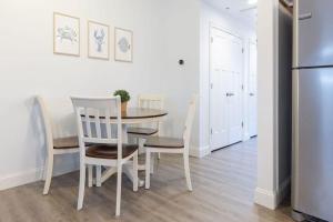 a kitchen with a table and chairs and a refrigerator at Steps to Beach King Bed Hampton Beach Hideaway in Hampton