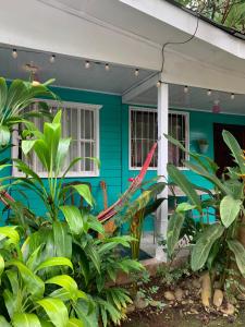 a blue house with a red umbrella on the porch at Casa Rio Verde in Cahuita