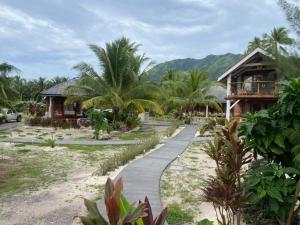 a path in front of a resort with palm trees at Moorea Reef Bungalows in Moorea