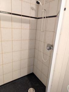 a shower in a bathroom with white tiles at Cosy Cabin close to Lake in Ludvigsborg +36 photos