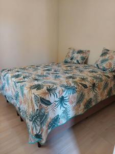 a bed in a bedroom with a floral bedspread at Aconchego da Zuca in Barra Grande
