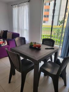 Serenity Inn Jamundi في Jamundí: طاولة وكراسي عليها صحن فاكهة +صورتان