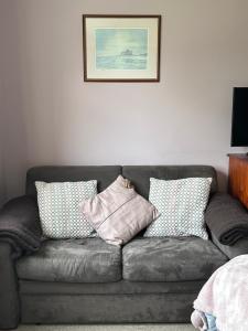 a gray couch with pillows on it in a room at Brada View Bamburgh in Bamburgh