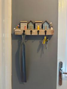 a wooden shelf with houses and keys on a wall at Brada View Bamburgh in Bamburgh