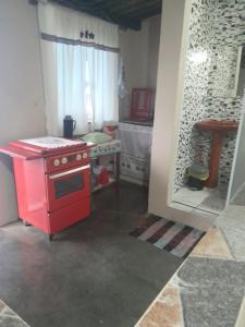 a kitchen with a red stove in a room at Casa São Thomé in São Thomé das Letras