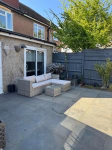 a couch sitting on a patio in front of a fence at Contemporary garden studio in Brighton! in Brighton & Hove