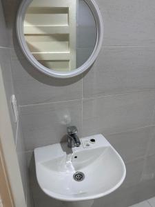 メディナにあるعماره الاوائل الحديثهの白い洗面台と鏡のあるバスルーム