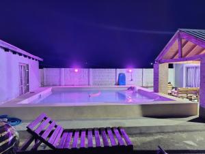 a swimming pool at night with a bench and lights at el quincho in Mercedes