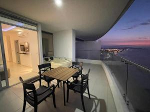 ein Esszimmer mit Tisch und Stühlen auf einem Balkon in der Unterkunft Tonsupa, Suite Grand Diamond Beach in Tonsupa