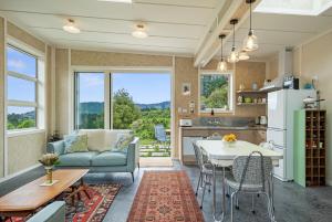 Reikorangi2 Bedroom Eco Cottage - Waikanae的配有沙发和桌子的厨房和客厅 更多22张照片