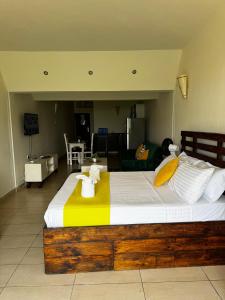 a bedroom with a large bed with towels on it at Golden Beachfront Studios Diani in Diani Beach