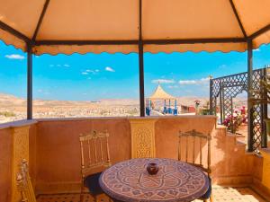 un tavolo e sedie su un balcone con vista di Kassr Annoujoum - Luxury Boutique Riad in the Heart of Fès Medina a Fes