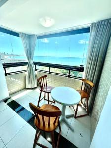 balkon ze stołem i krzesłami oraz widokiem na ocean w obiekcie Vista Incrível - Coral Gables Apt 603 w mieście João Pessoa