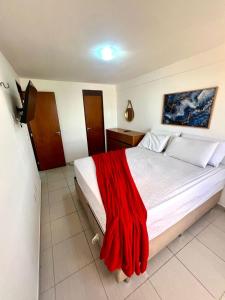 sypialnia z łóżkiem przykrytym czerwonym kocem w obiekcie Vista Incrível - Coral Gables Apt 603 w mieście João Pessoa