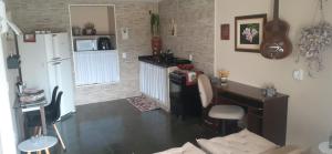 a kitchen with a refrigerator and a table and a desk at Studio do Wander in Amparo