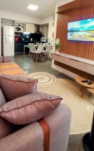a living room with a couch and a flat screen tv at Ap 509 Ed Santorini Ponta Verde in Maceió +27 photos