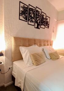 a bedroom with a white bed with four pictures on the wall at Ap 509 Ed Santorini Ponta Verde in Maceió