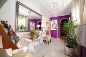 pasillo con paredes de color púrpura y espejo en Hostal Adriano, en Madrid